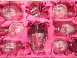 a pink box with six glass ornaments inside of it
