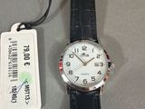 une montre posée sur une table à côté d'une étiquette de prix