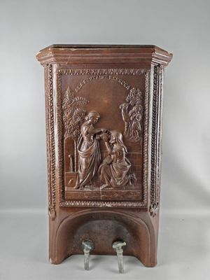 une vieille armoire en bois ornée d'une sculpture représentant un homme et une femme