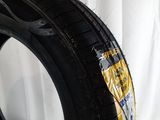 a close up of a tire on a white surface with a white curtain in the background