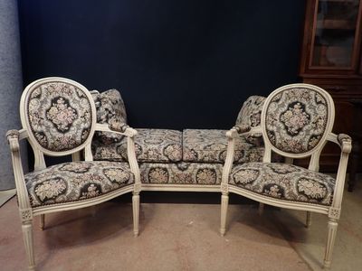 two chairs and a couch in a room with a blue wall