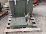 une grande caisse verte posée sur une palette dans une cour
