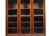 une bibliothèque ancienne avec des portes vitrées et des étagères en bois