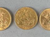 three gold coins with a picture of a man and a woman on them