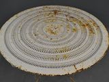 an old white table with a rusted top on a gray surface