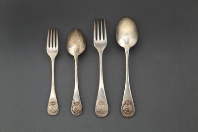 quatre cuillères et une fourchette sont alignées sur une table