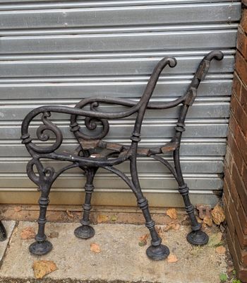 un banc en métal situé devant un bâtiment