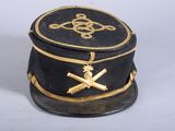 un petit chapeau noir orné d'une décoration dorée