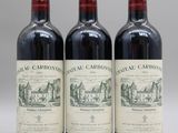 trois bouteilles de vin rouge posées côte à côte sur une table