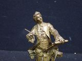 a bronze statue of a man holding a gun and a book