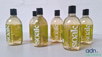four bottles of liquid sitting on top of a white table