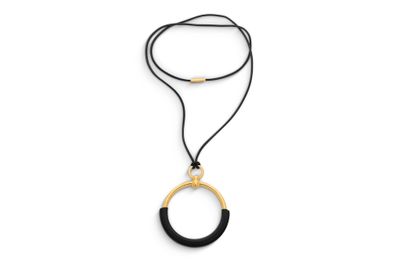 un collier noir et doré avec un pendentif circulaire, monté sur un cordon noir