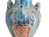 un vase bleu orné d'un oiseau sur fond blanc