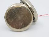 a silver pocket watch with a red string around it