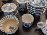 many blue and white dishes and cups on the table