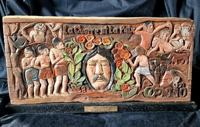 carvings of people and animals are on display on a black cloth
