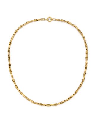 un collier à chaîne en or orné de petites perles sur fond blanc