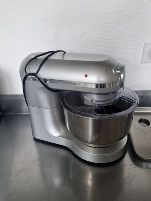 a silver mixer sitting on a kitchen counter next to a pot