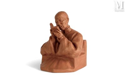 figurine of a monk sitting on a chair with his hands crossed