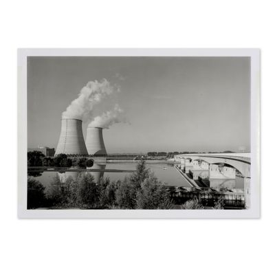photographie en noir et blanc d'une centrale nucléaire d'où s'échappe de la fumée