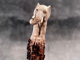 a statue of an elephant on top of a tree stump