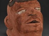 a clay mask with a black face and brown hair
