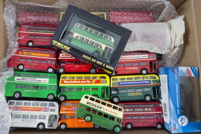 plein de petits bus dans une boîte posée par terre