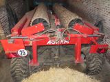 a tractor that is parked in a barn with hay