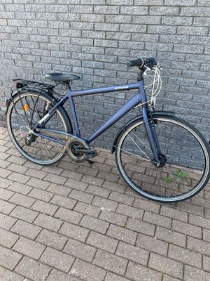 un vélo appuyé contre un mur de briques sur le trottoir