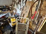 a pile of tools and a ladder in a room