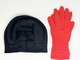 pair of red and black knitted gloves and a beanie on a white surface