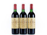 three bottles of red wine sitting next to each other on a white surface