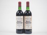 deux bouteilles de vin rouge posées l'une à côté de l'autre sur une surface blanche