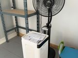 an image of a fan in a room next to a stack of books