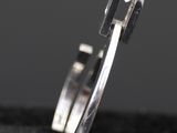 a close up of a silver ring on a black cloth
