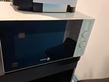 two microwaves sitting on top of each other on a table
