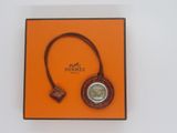 an orange box with a watch and a keychain in it