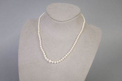 un collier de perles blanches sur un mannequin, muni d'un fermoir en argent