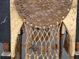an old chair that has a leather and rope decoration on it