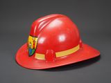red fireman ' s hat with a crest on the side