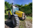 the tractor is parked on the side of the road in the grass