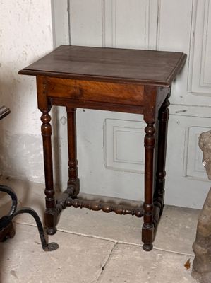 une petite table avec un plateau en bois, placée devant une porte
