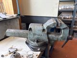 an old vise on a workbench in a workshop