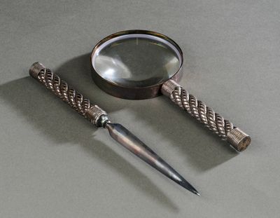 une loupe et un couteau posés sur une table