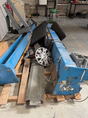 une machine bleue posée sur une palette dans un garage