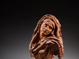 un buste sculpté représentant une femme portant un voile sur la tête