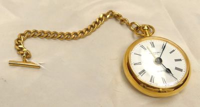 une montre de poche en or à laquelle est attachée une chaîne