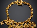 a close up of a gold bracelet on a black background