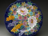 une assiette bleue décorée de fleurs et de feuilles
