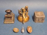 une petite statue représentant un homme assis sur un tabouret, à côté d'autres objets